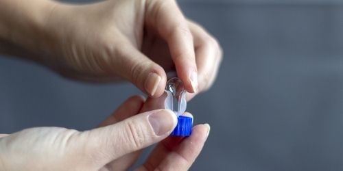 Person holding contact lenses